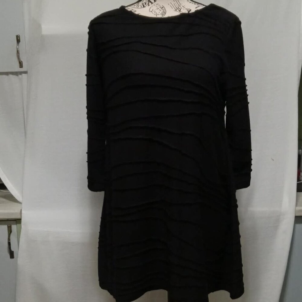 A slightly stretchy vintage black dress with a textured wave pattern